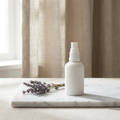 Nidra Lavender Pillow Mist 100ml bottle with a sprig of dried lavender, marble surface